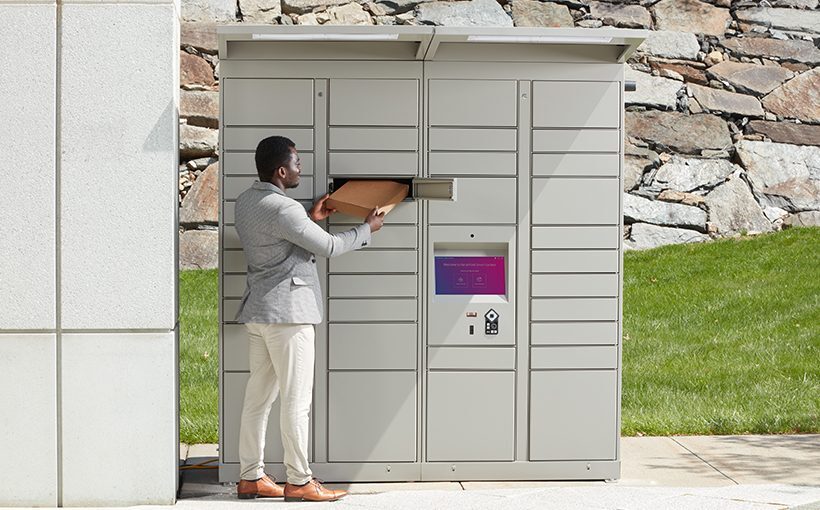 Hombre que utiliza taquillas inteligentes exteriores para recoger un paquete