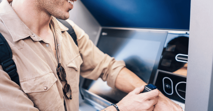 Hombre usando cajero automático con reloj inteligente 