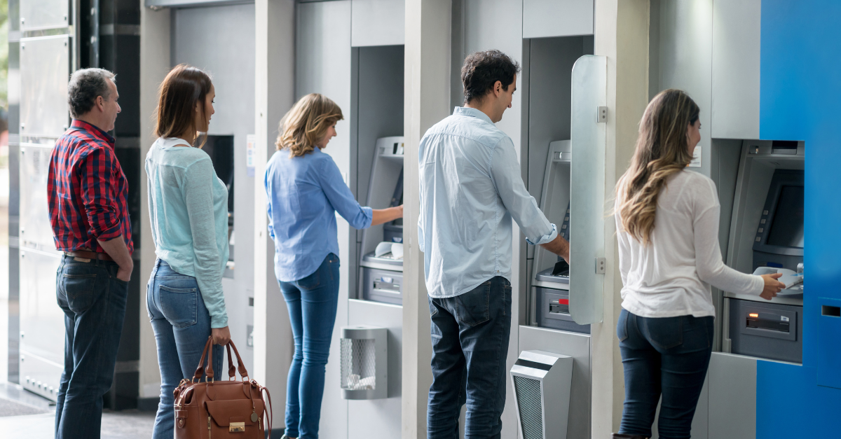 Fila de personas que utilizan cajeros automáticos