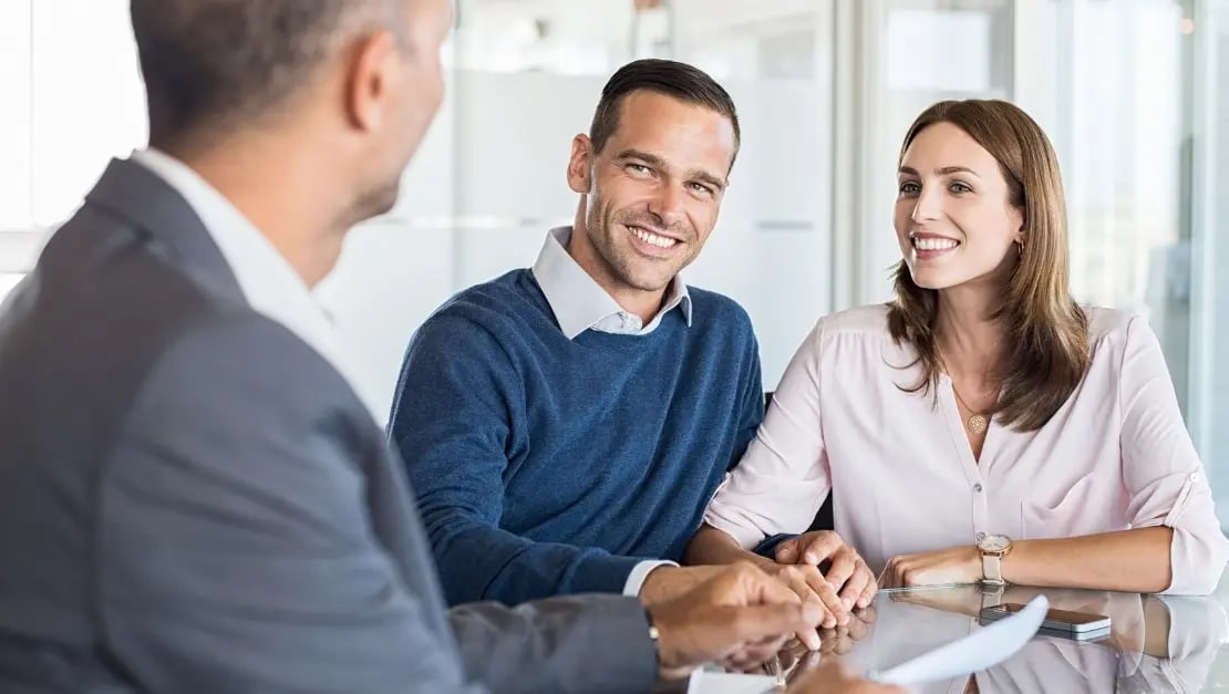 Hombre y mujer reunidos con un asesor financiero 