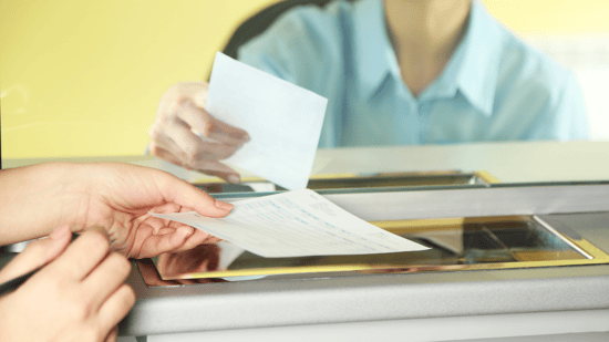 Cajero de banco entregando un cheque al cliente 