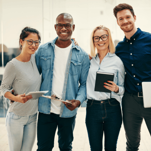 Equipo de pie y sonriente con tabletas móviles