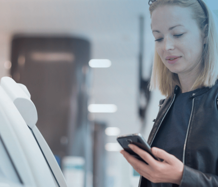 Mujer al teléfono usando una máquina de autoservicio para copiar