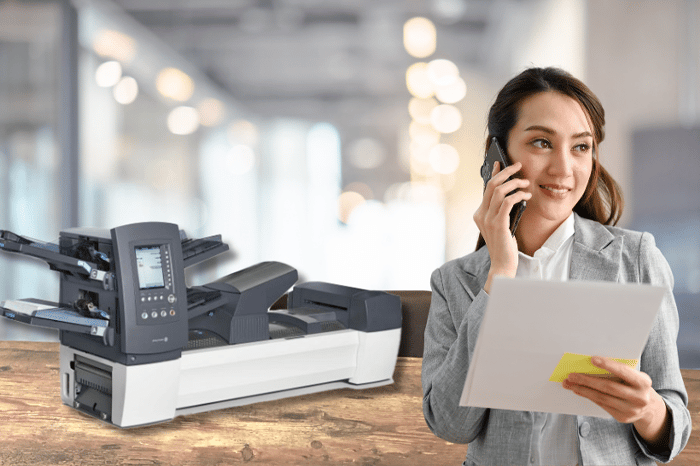 Mujer al teléfono delante de una máquina de inserción de relés