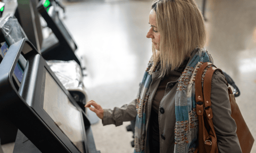 Mujer utilizando máquina de autoservicio en una copia bancaria