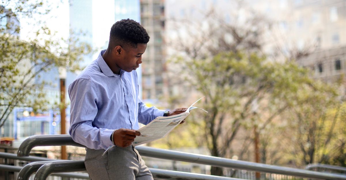 Hombre leyendo el periódico al aire libre