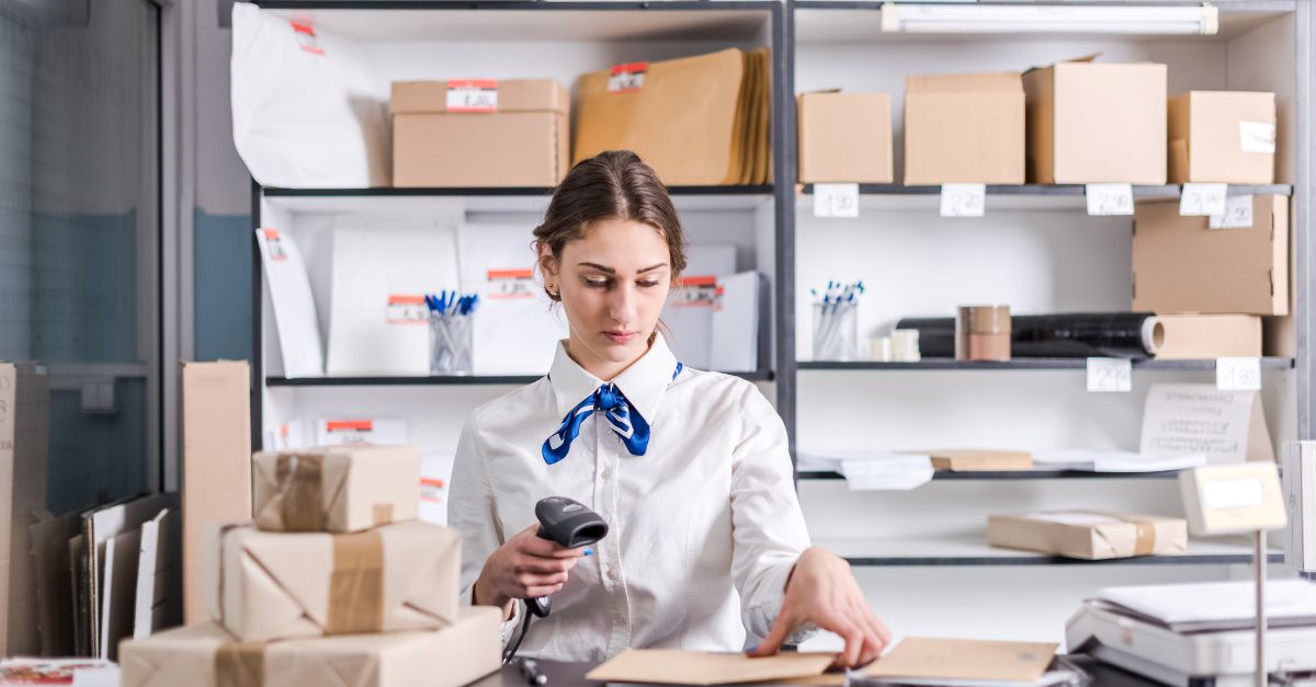 Mujer escaneando cajas en la oficina de correos