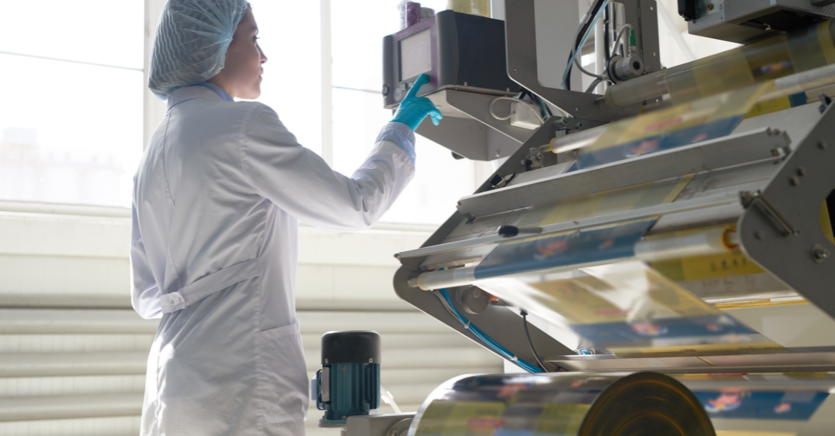 Mujer con bata de laboratorio utilizando una máquina de impresión de tinta industrial 