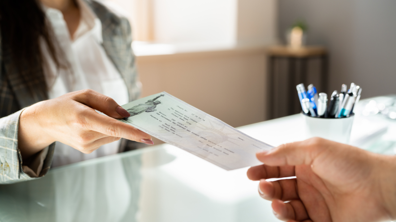 Bank teller handing cashier's check to customer 