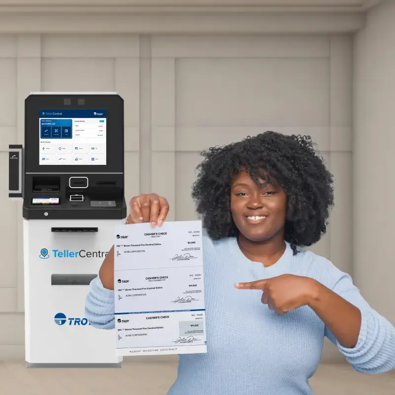 Mujer sosteniendo un cheque frente a un autoservicio TellerCentral